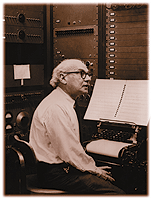 man sitting in front of large instrument